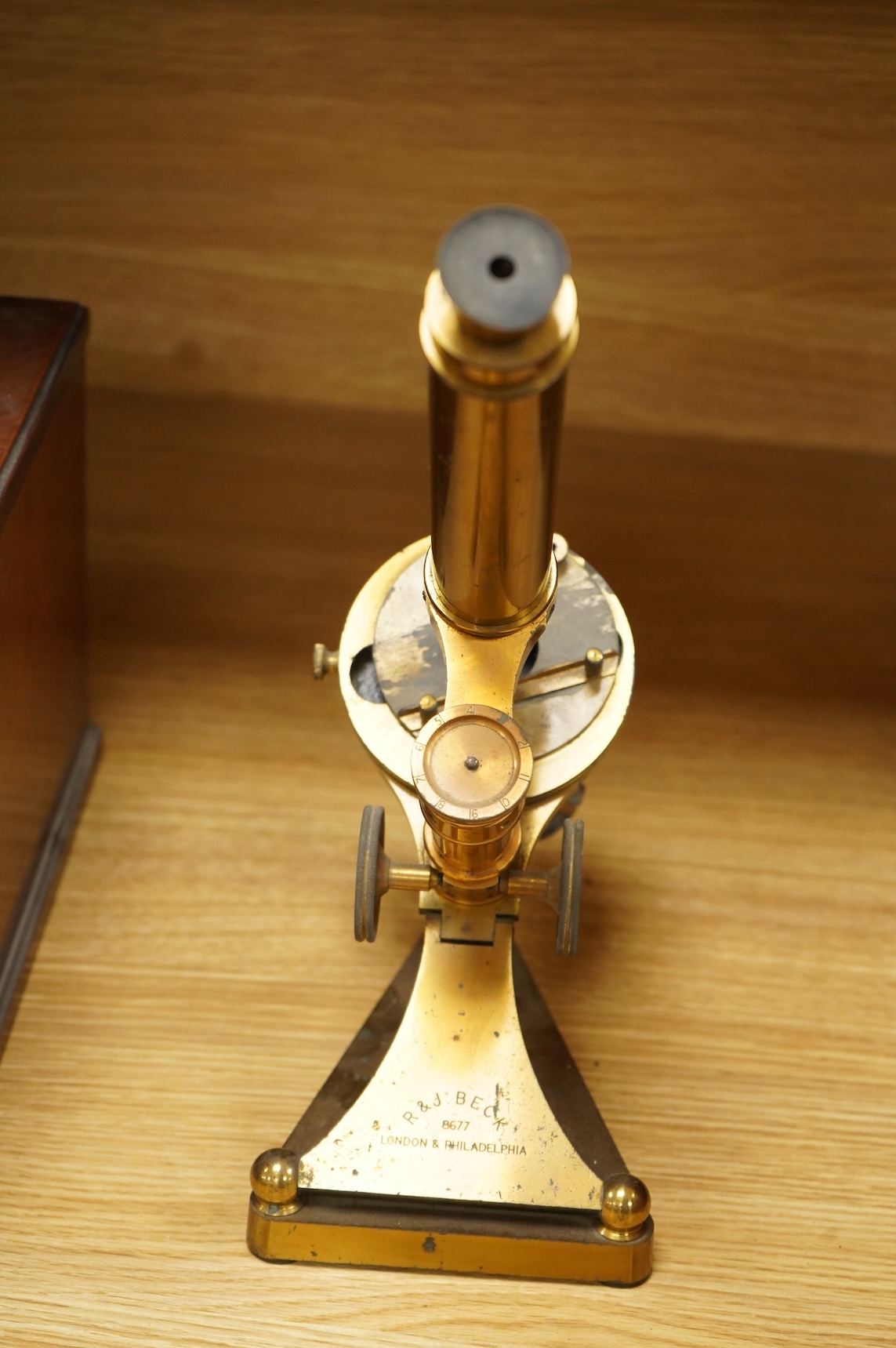A late 19th century brass compound monocular microscope, by R and J. Beck, mahogany cased, with two objectives, 2 eyepieces and miscellaneous slides, the case dimensions; 40.5 x 15.5x 18cm, together with a small early 19